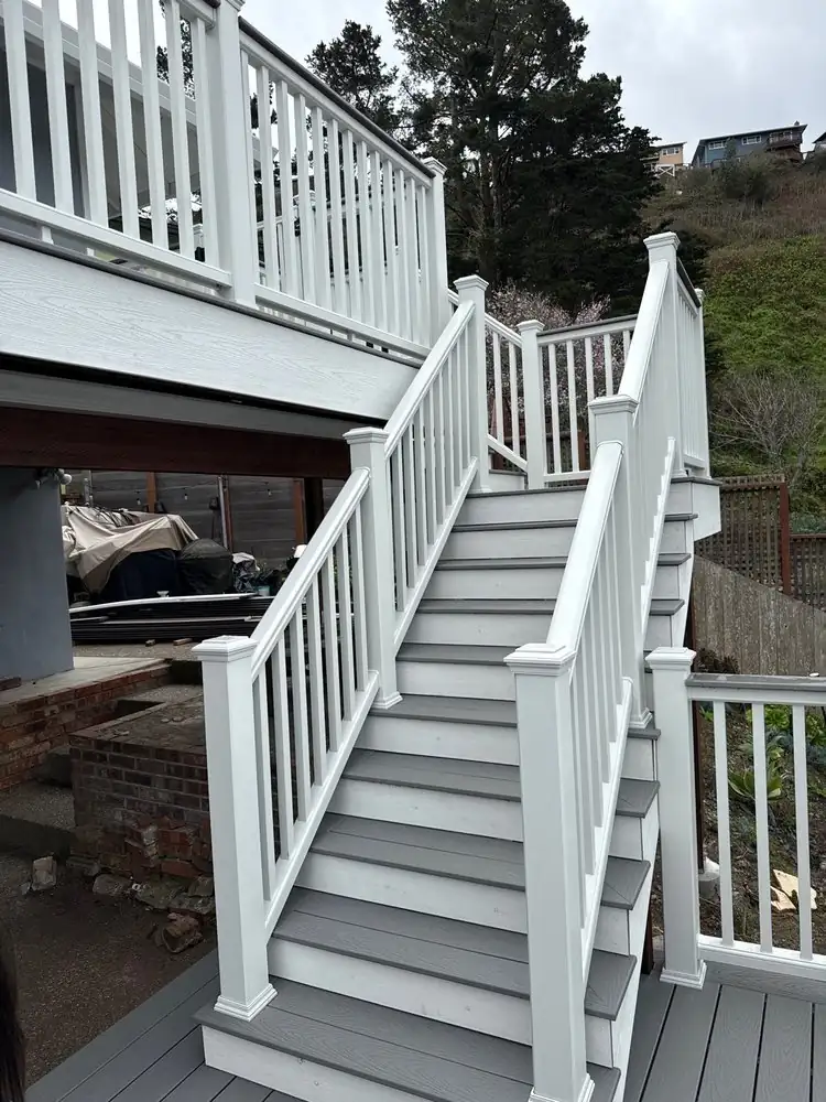 Deck staircase with white railing and gray treads