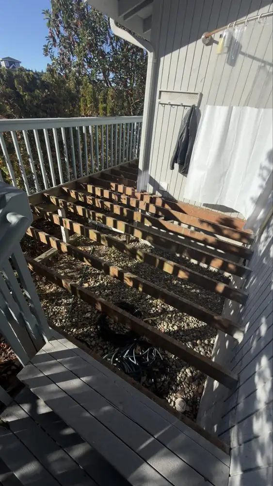 Exposed deck joists beside the house after surface boards have been removed